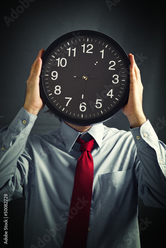 Photo: Businessman with black clock, deadline concept Businessman with black clock, deadline concept