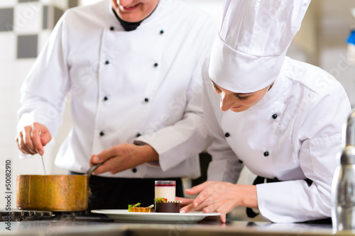 Photo: Chef team in restaurant kitchen with dessert Chef team in restaurant kitchen with dessert