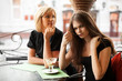 Two young women at sidewalk cafe