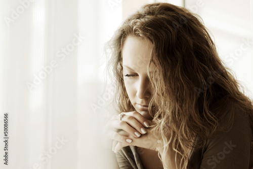 Photo: Sad woman against a window Sad woman against a window
