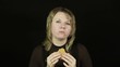 Woman eating hamburger on a black background