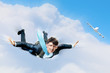 Young businessman flying with parachute on back