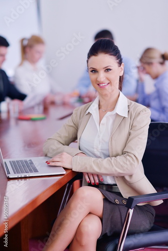 Photo: business woman with her staff in background at office business woman with her staff in background at office