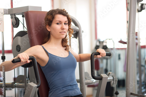 Photo: Young woman training in the gym. Young woman training in the gym.