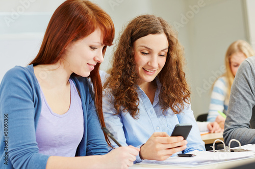 Photo: Junge Frauen im Unterricht mit Smartphone Junge Frauen im Unterricht mit Smartphone