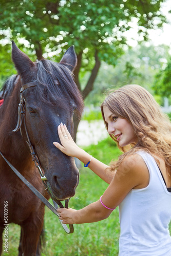 Photo: Young girl to train a horse.Focus on horses face. Young girl to train a horse.Focus on horses face.