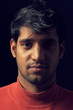 Portrait of young Indian man over dark