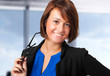 Young businesswoman holding her glasses