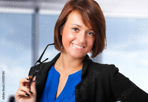 Photo: Young businesswoman holding her glasses Young businesswoman holding her glasses
