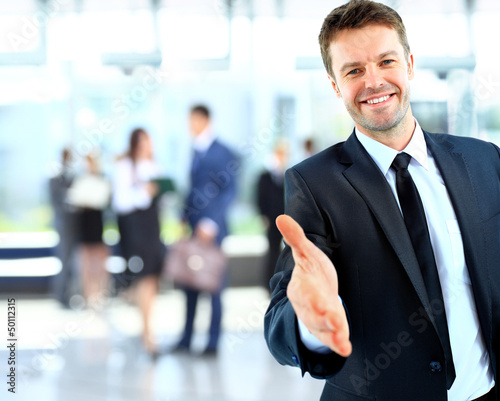 Photo: Portrait of a successful businessman giving a hand Portrait of a successful businessman giving a hand