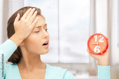 Photo: woman holding alarm clock woman holding alarm clock