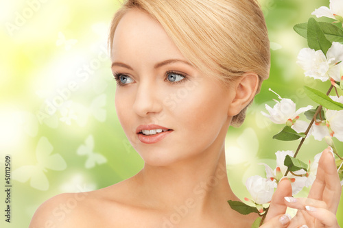 Photo: beautiful woman with flowers on twig beautiful woman with flowers on twig