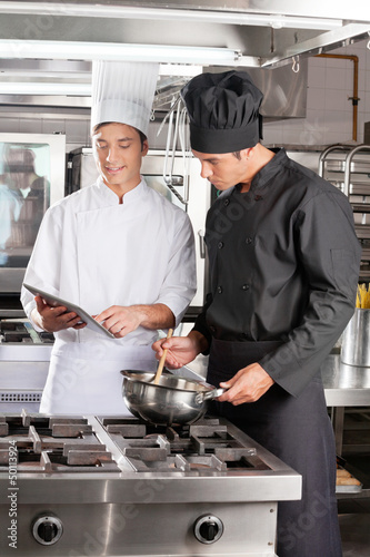 Photo: Young Chefs With Digital Tablet Preparing Food Young Chefs With Digital Tablet Preparing Food
