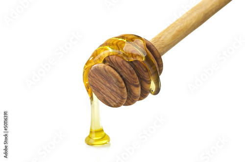 Photo: Honey dripping from a wooden of olives dipper Honey dripping from a wooden of olives dipper