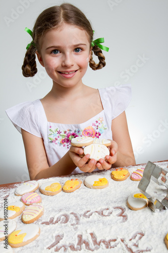 Photo: Happy Easter - lovely girl making easter cookies Happy Easter - lovely girl making easter cookies