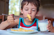 Cute little boy having delicious breakfast