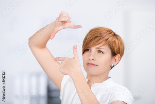 Photo: junge frau schaut durch fingerrahmen junge frau schaut durch fingerrahmen