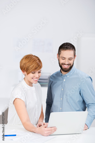 Photo: junge kollegen schauen auf laptop junge kollegen schauen auf laptop