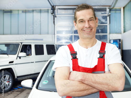 Photo: Master mechanic is satisfied with his job in a garage Master mechanic is satisfied with his job in a garage