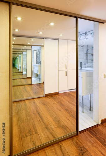 Photo: Sliding-door mirror wardrobe in modern hall interior with infini Sliding-door mirror wardrobe in modern hall interior with infini