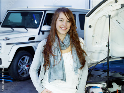 Photo: Female customer in a garage is satisfied after service Female customer in a garage is satisfied after service