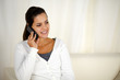 Charming young woman conversing on cellphone