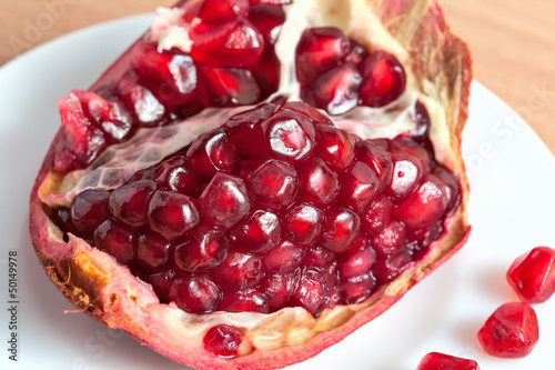 Photo: The cut pomegranate and grains on a plate The cut pomegranate and grains on a plate