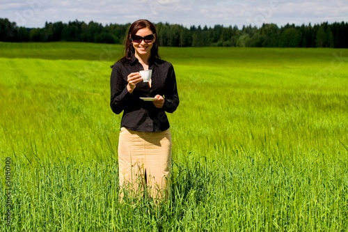 Photo: Woman drinking coffee in a field Woman drinking coffee in a field
