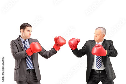 Photo: Two businessmen having a fight with boxing gloves Two businessmen having a fight with boxing gloves