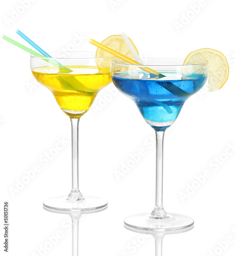 Photo: Yellow and blue cocktails in glasses isolated on white Yellow and blue cocktails in glasses isolated on white