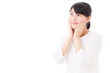 a young asian woman making up