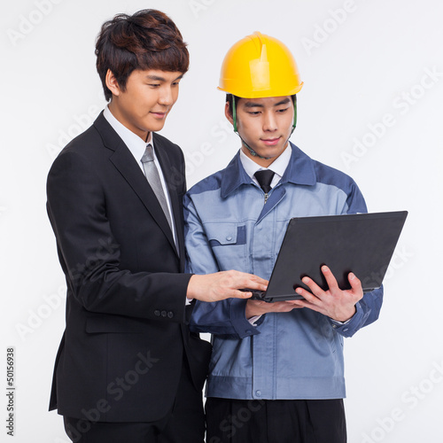 Photo: Business man and engineer looking laptop. Business man and engineer looking laptop.