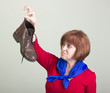 Unhappy woman holding a dirty shoe.