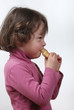 Foto: A young girl eating a bun A young girl eating a bun
