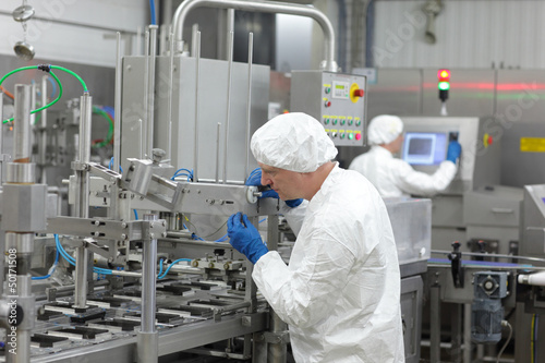Photo: two workers at production line in plant two workers at production line in plant