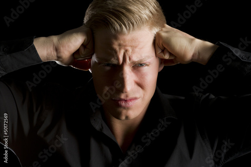 Photo: Low key portrait of overburdened young man. Low key portrait of overburdened young man.