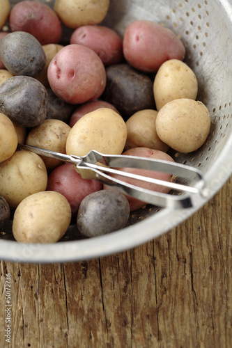 Photo: Peeler in colander with multicolored potatoes Peeler in colander with multicolored potatoes