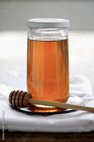 Photo: Honey in jar with dripper Honey in jar with dripper