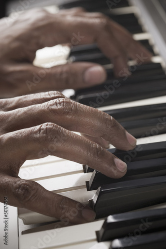 Photo: Mixed race man playing the piano Mixed race man playing the piano