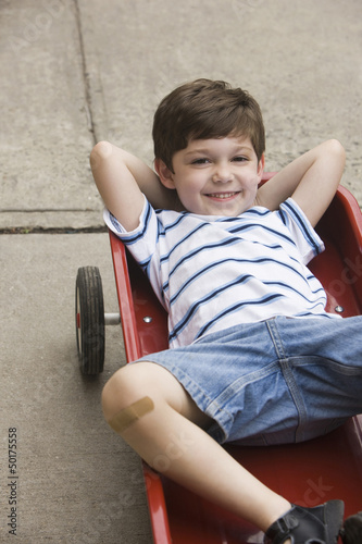 Photo: Caucasian boy laying in wagon Caucasian boy laying in wagon