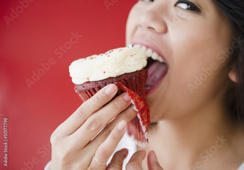 Photo: Pacific Islander woman eating cupcake Pacific Islander woman eating cupcake