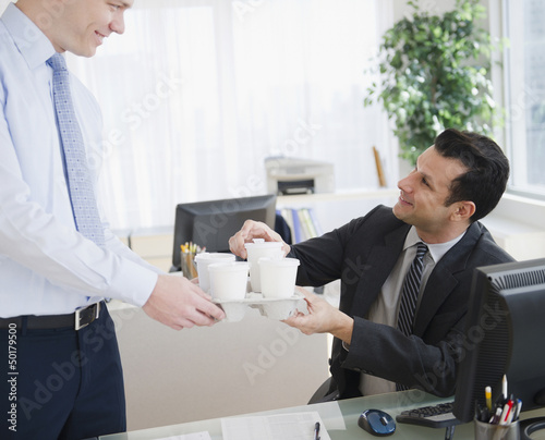 Photo: Businessman bringing coffee to co-worker Businessman bringing coffee to co-worker