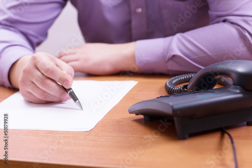 Photo: Businessman sitting at office desk Businessman sitting at office desk
