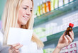 Apothekerin hält Rezept und Arzneimittel