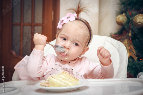Photo: Little girl with a sweet cake in birthday Little girl with a sweet cake in birthday