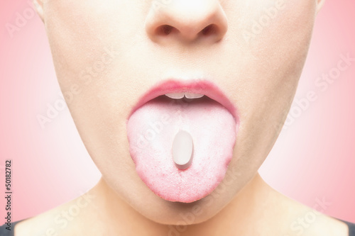 Photo: Caucasian woman with pill on tongue Caucasian woman with pill on tongue