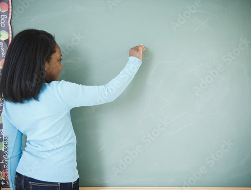 Photo: Black student writing on blackboard Black student writing on blackboard