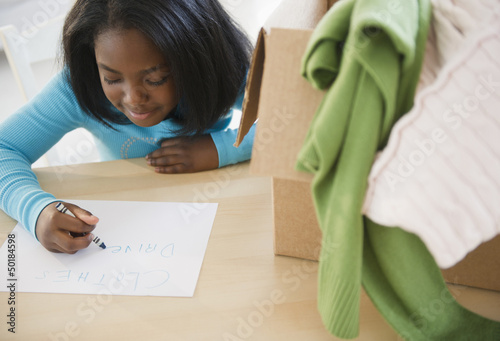 Photo: Black girl donating clothing to charity Black girl donating clothing to charity
