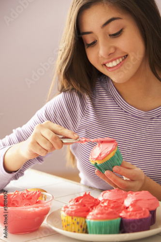 Photo: Mixed race girl frosting cupcakes Mixed race girl frosting cupcakes