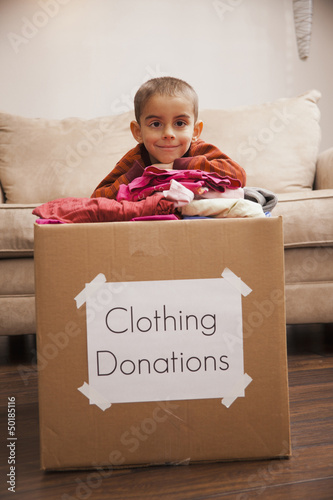 Photo: Caucasian boy donating clothing Caucasian boy donating clothing